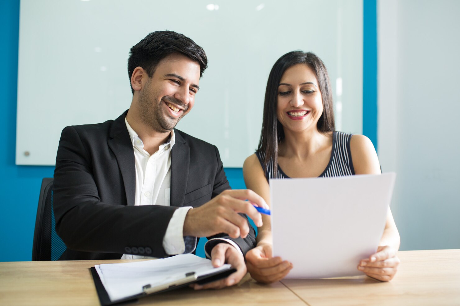 ejecutivos-negocios-positivos-riendo-mientras-leen-contrato_1262-18019